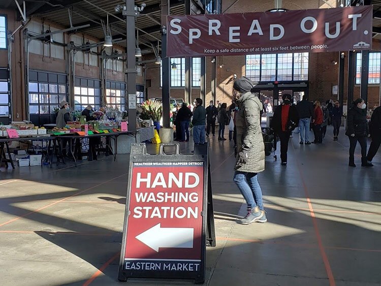 The market is visibly emptier these days, with signs indicating safety measures such as hand washing stations and signs reminding shoppers to spread out.