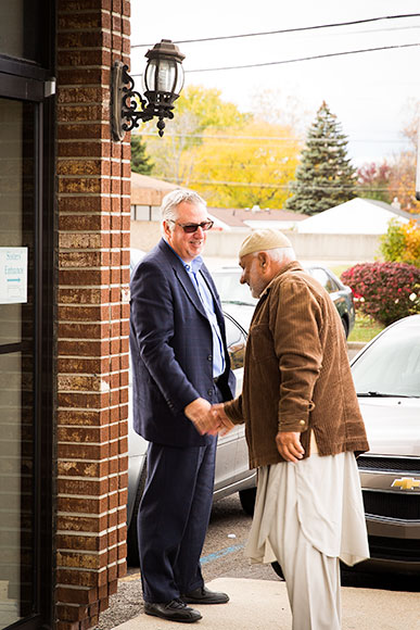 Rev. Michail Curro greets members of Macomb's Muslim community outside of a mosque