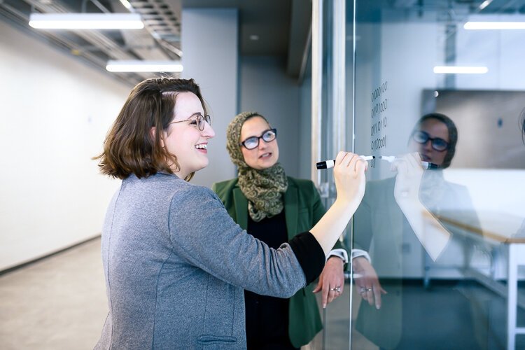 Katelyn Coberley and Bia Hamed work at Eastern Michigan University's Sill Hall.