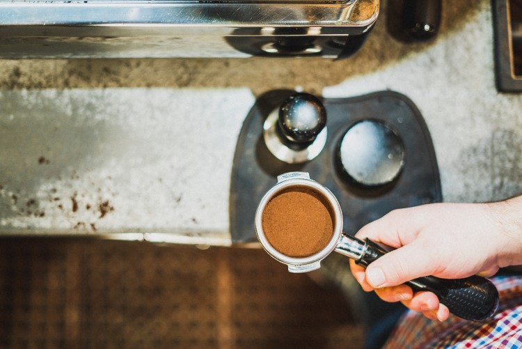 A Live Oak employee goes through the espresso tamping process, creating a "pellet" of coffee grounds through which the hot water from the espresso machine will penetrate evenly.