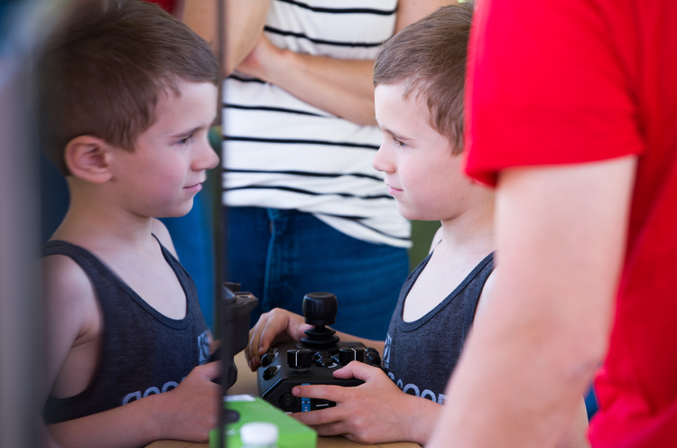 A child controls a robot remotely during the festival.