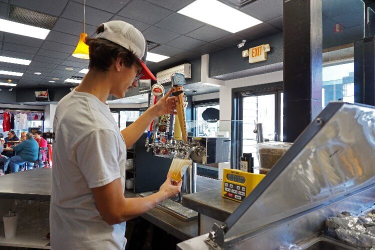 Elijah Silva pours a beer on tap.