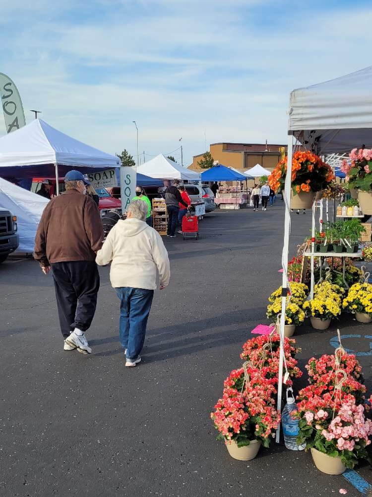 A couple takes an early morning stroll through the Midland Area Farmers Market.