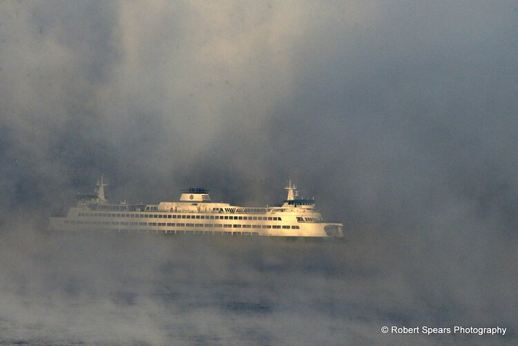 A ferry captured in the fog of the morning.