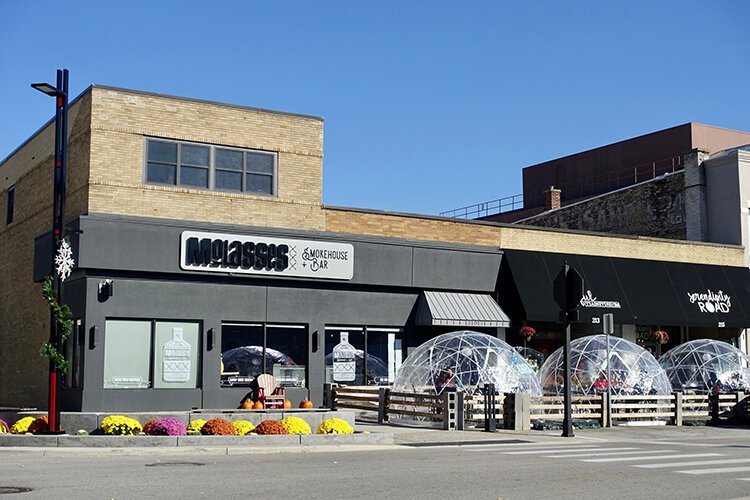 Heated igloos are set up outside of Molasses Smokehouse & Bar in downtown Midland for outdoor dining.