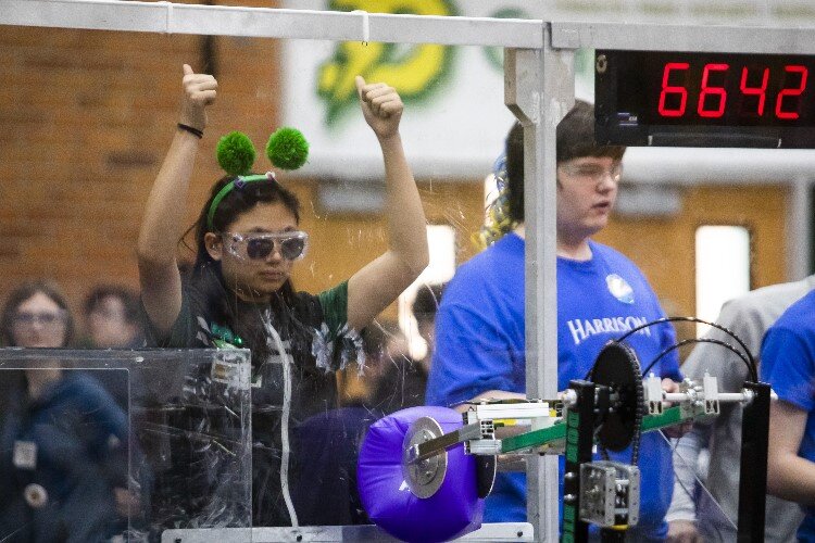 Dow sophomore Lucy Tang, a team member of "The Charge" of Dow High School, gives two thumbs up to her teammates while competing in a match during the FIRST.