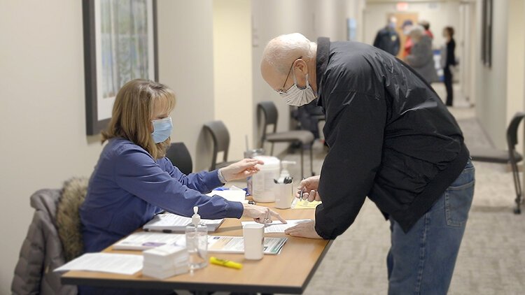 Dennis Hucul, of Midland, completes authorization forms with the help of Michelle Abedrabo, R.N., data specialist II, prior to his COVID-19 vaccination earlier this month.