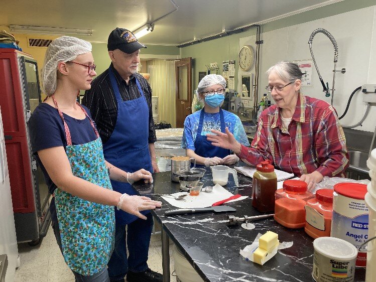 Patricia McFarland (far right) teaches prep of caramel coating to (from left), Cerease Martin, and Charlotte Raft. Gene McFarland looks on.  