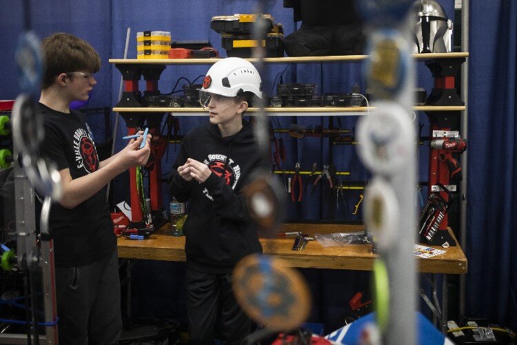 Team members of "E-Ville Empire" of Garber High School work on their robot.