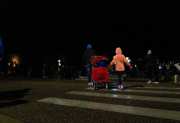 Crowds bundle up to brave the rainy weather. Salvation Army volunteers pass out hot chocolate just off Main Street.