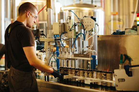 Employee Keith Adams manages the 4-head CO2 purge and 4-head filler section of the canning process.