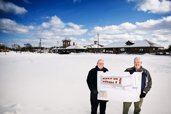 Bill Merry of HomeStretch and Dan Baldwin of Habitat for Humanity stand on property near the corner 