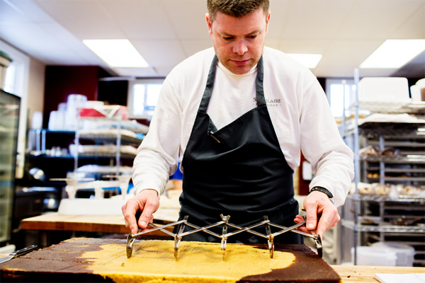 Pleasanton Bakery owner Jonathan St. Hilaire hand cuts pumpkin brownies made with local pumpkin. / Elizabeth Price