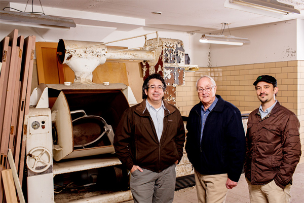 Raymond Minervini Jr., Don Coe, J. Robert Sirrine in front of an old Hobart dough mixer that was used during the Traverse City State Hospital era. / Elizabeth Price