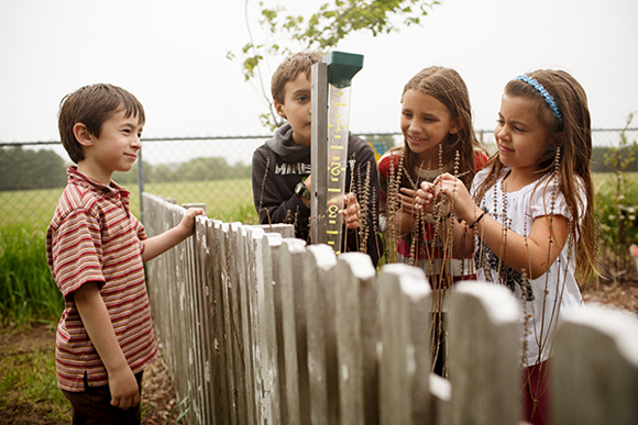 Mill Creek second graders study the water gauge in their native plants garden.