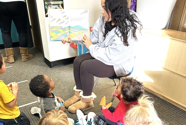 Ms. Mariah reads to children attending Jumpstart.