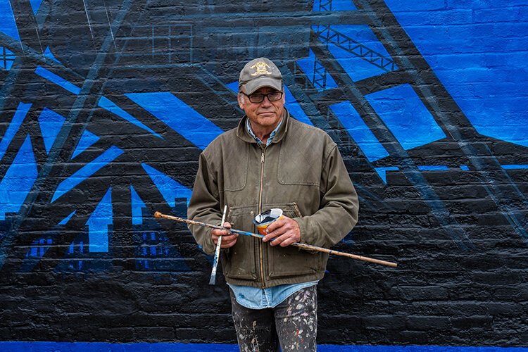 Steve Nordgren poses for a photo in front of his artwork.