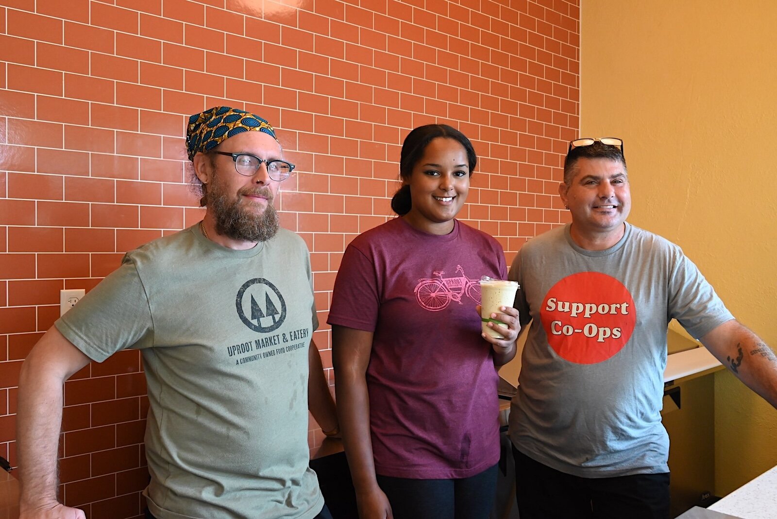 Uproot Market and Eatery staﬀ include Jeremiah Shelton, Prepared Foods Division Manager, Bella Howard, Barista, and Scott Wright, Kitchen Manager.
