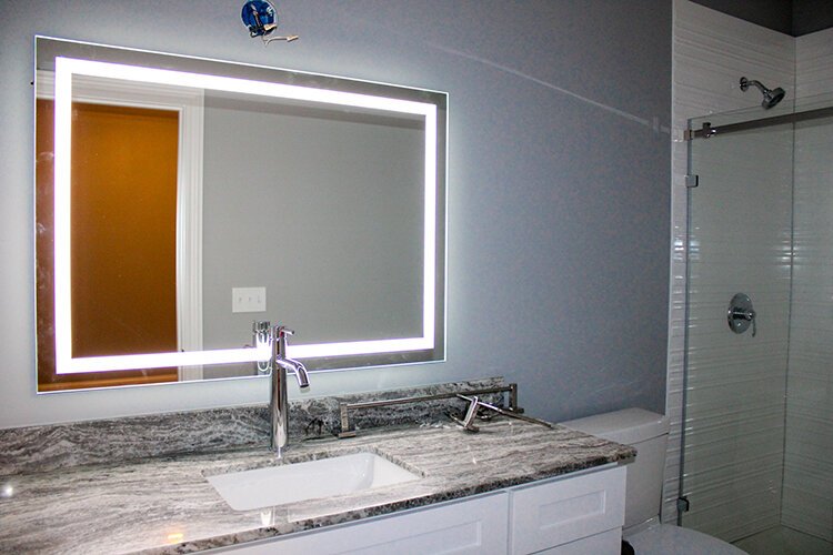 Bathrooms at the newly-constructed lofts at the Wrigley Center feature glass showers and lighted mirrors.