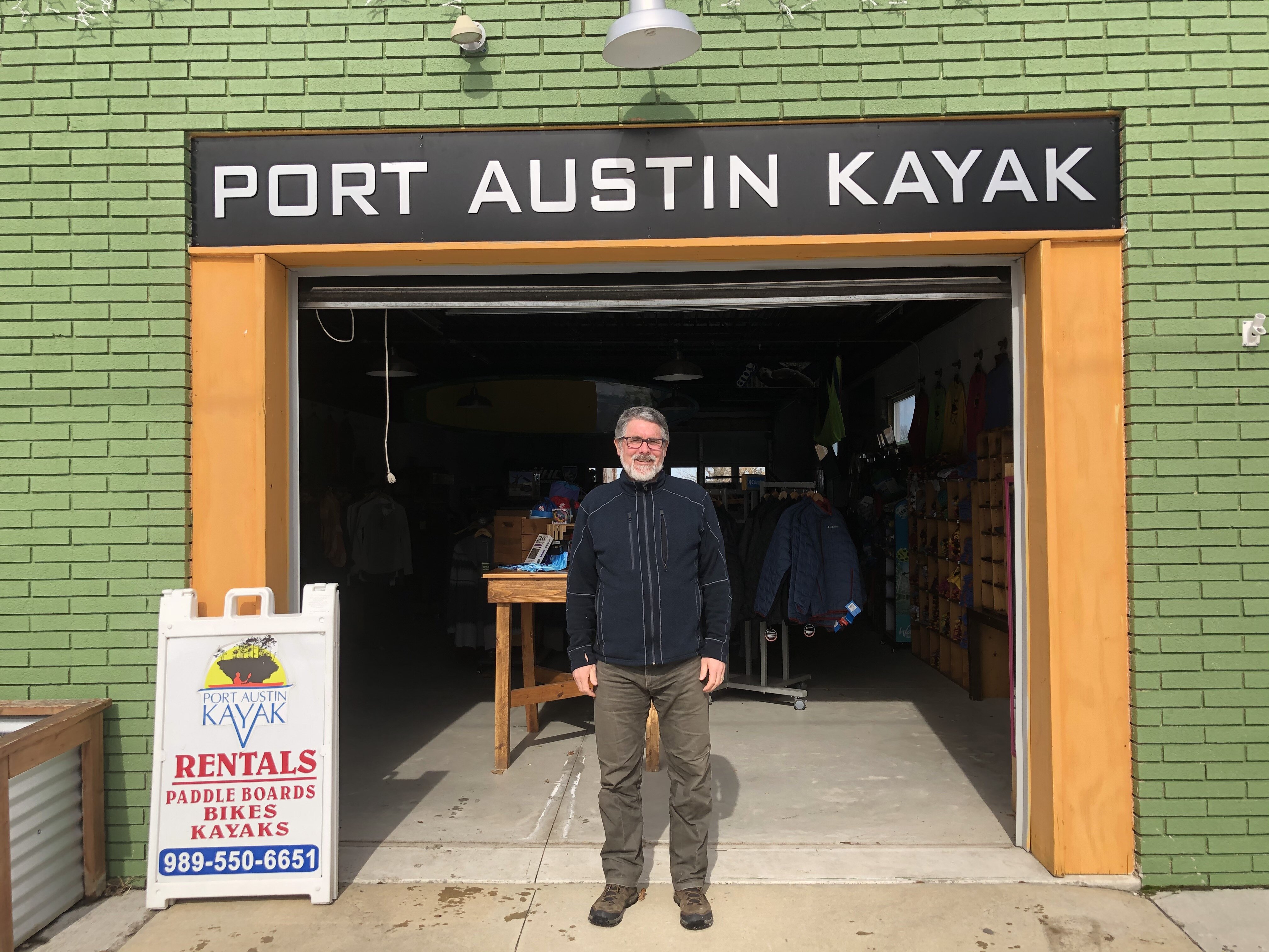 Entrepreneur Chris Boyle poses outside his first Port Austin venture: Port Austin Kayak.