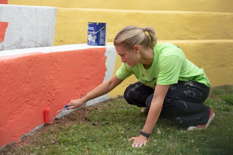 Monroe artist Presley Bergmooser works on a mural in the city's Boyd Park. 