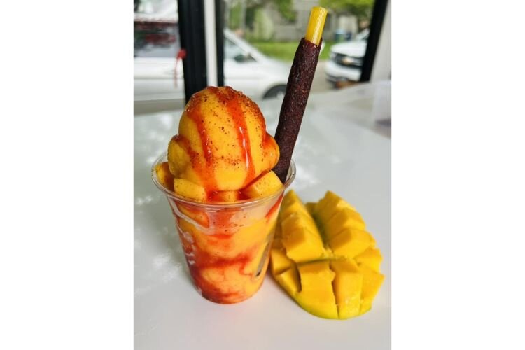 Mangonada; a mango sorbet topped with chamoy, a savory sauce made from pickled fruit like apricots, and Tajin, a seasoning made with chili peppers, lime, and salt.