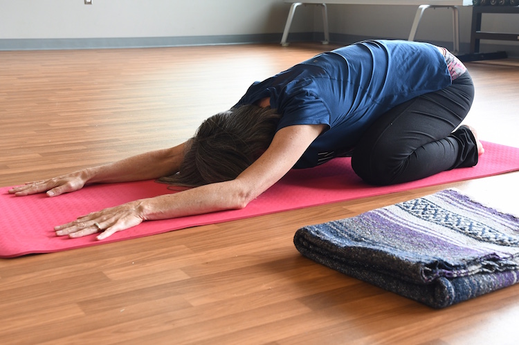 Cindy A. demonstrates one of the yoga positions she uses in her 12-step yoga class at the Trinity Community Center.