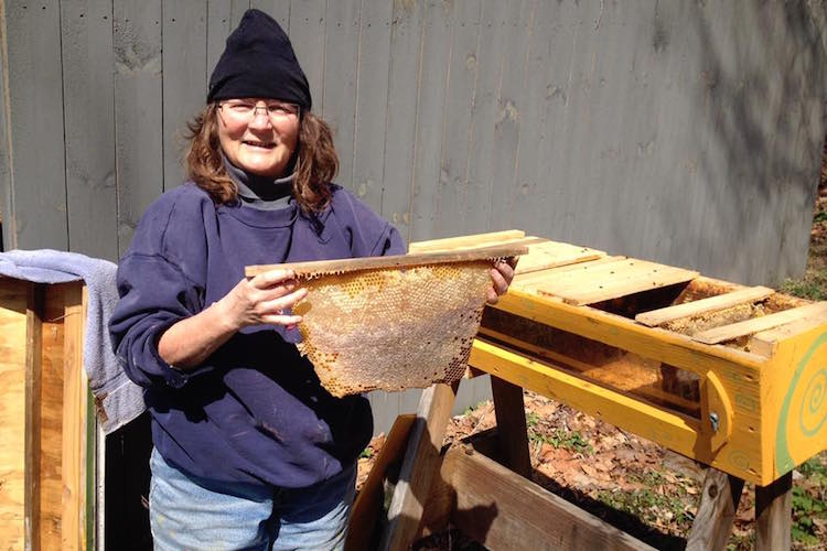 Dale Abbott checks the apiary, part of the Trybal Revival Eastside Eco Garden (TREE).