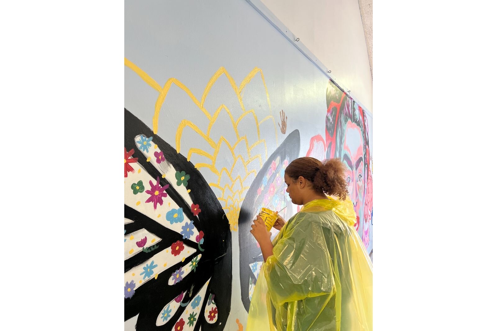 A student carefully paints their part of the mural. 