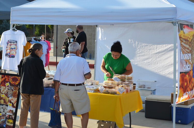 The couple works together to help customers at the Kalamazoo Farmers Market.