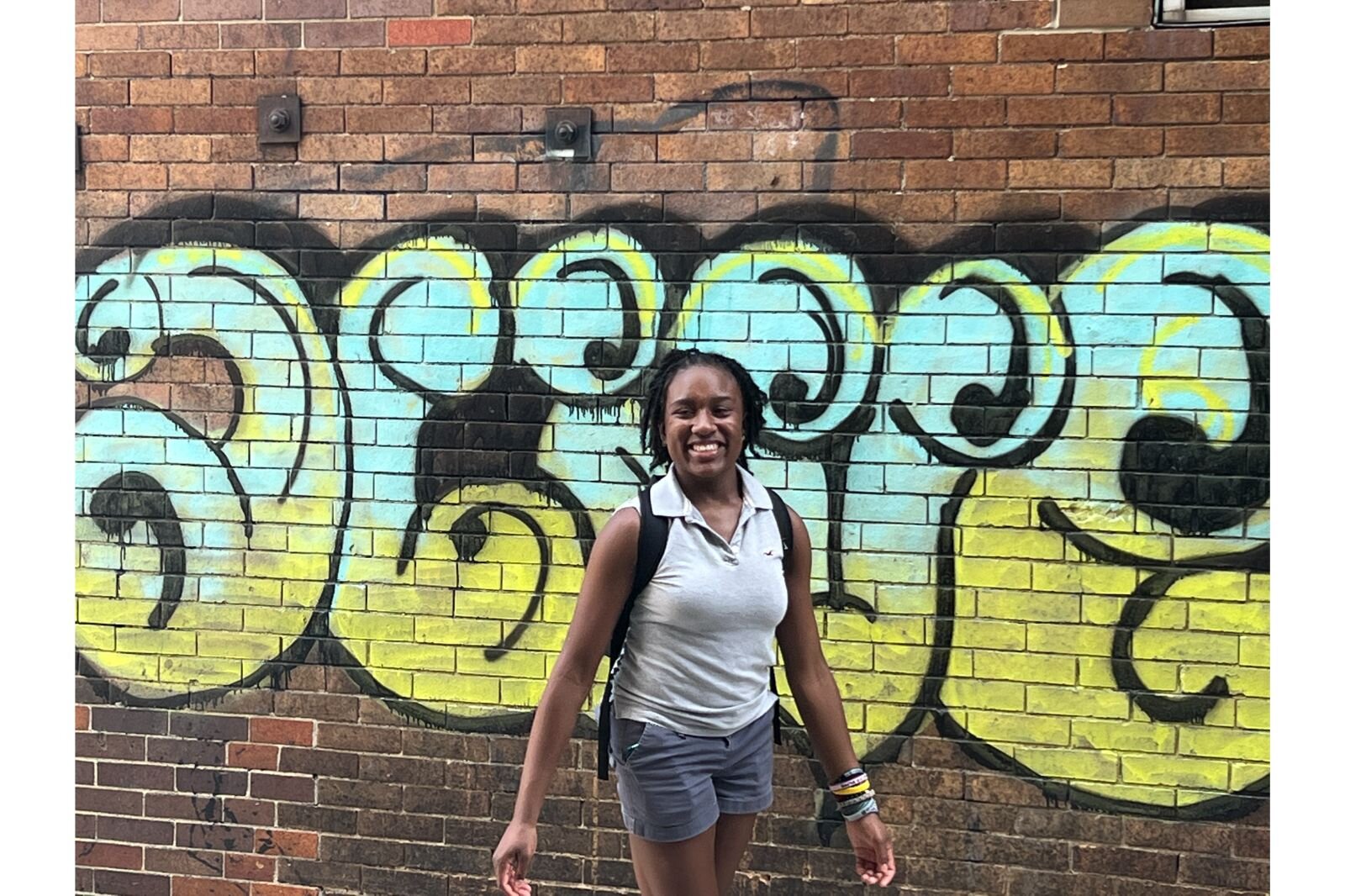 Davia McCoy poses in front of some artwork.