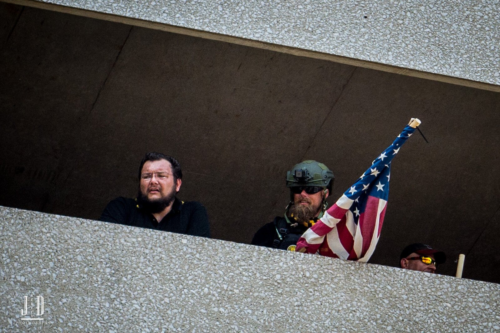 Proud Boys look out from the safety of the Raddison Parking ramp.