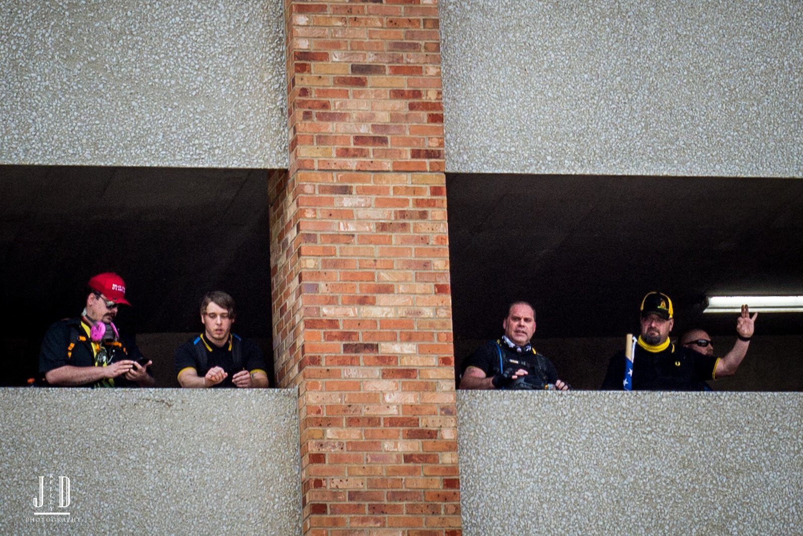 Proud Boys look out from the safety of the Raddison Parking ramp.