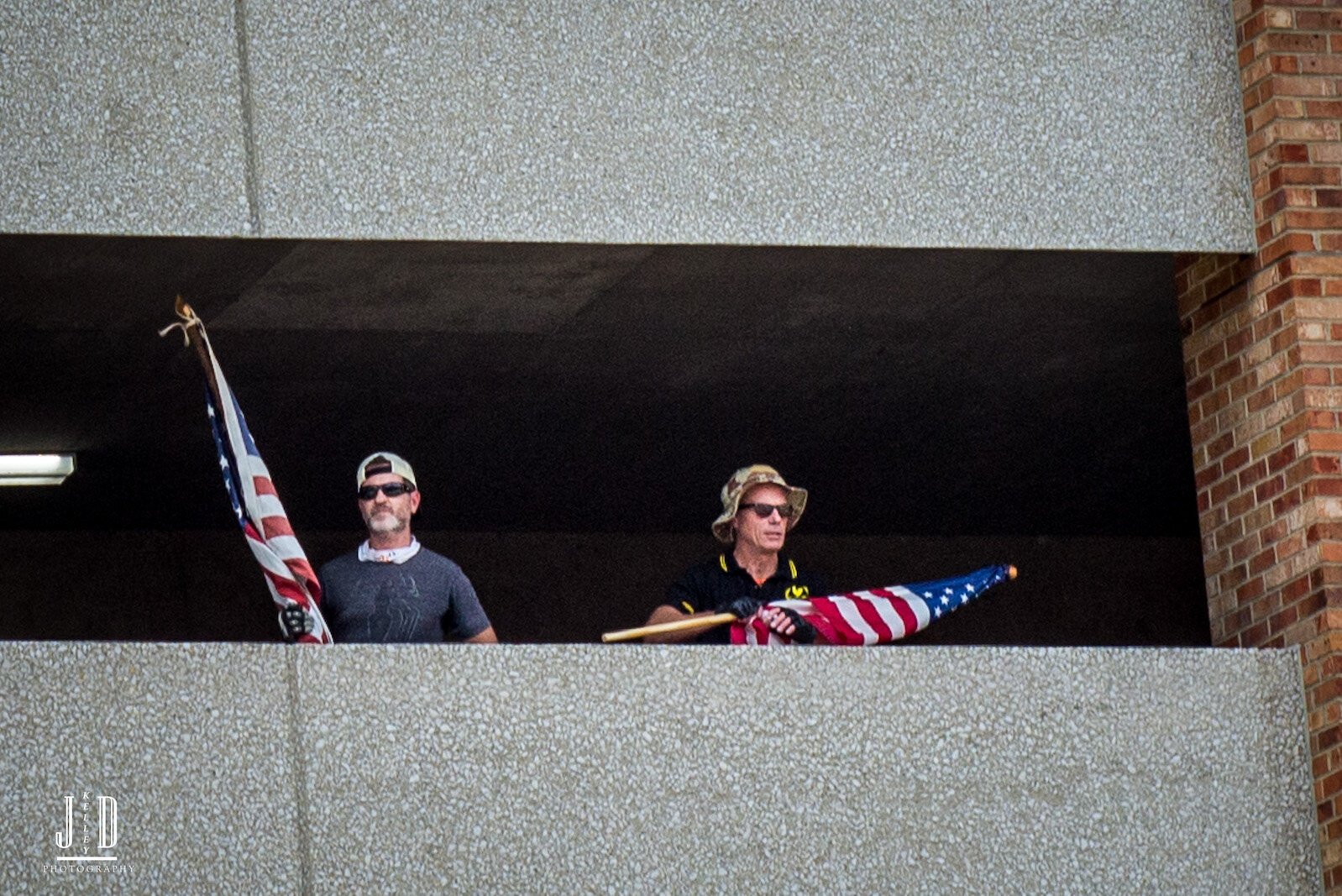 Proud Boys look out from the safety of the Raddison Parking ramp.