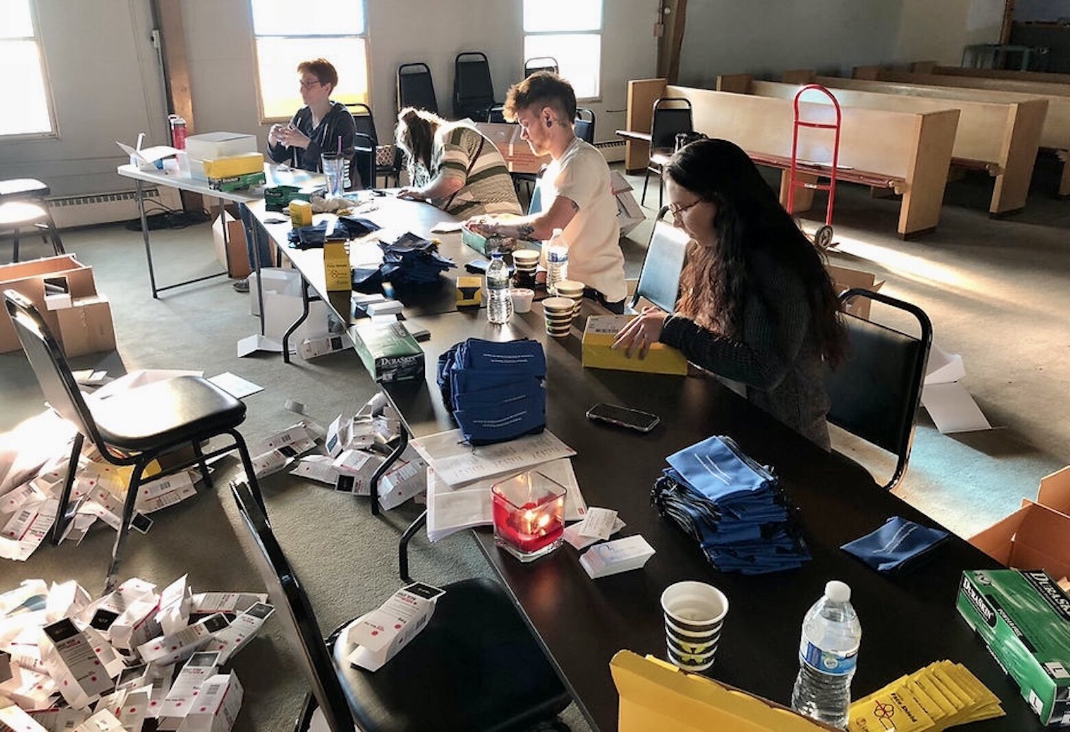 Volunteers are shown assembling Narcan kits as part of COPE Network’s Naloxone Distribution Program. The medication is used to counteract the initial effects of a drug overdose.