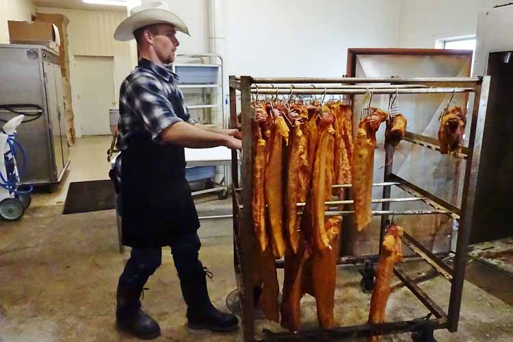 Justin moves meat from the smoker to the meat locker