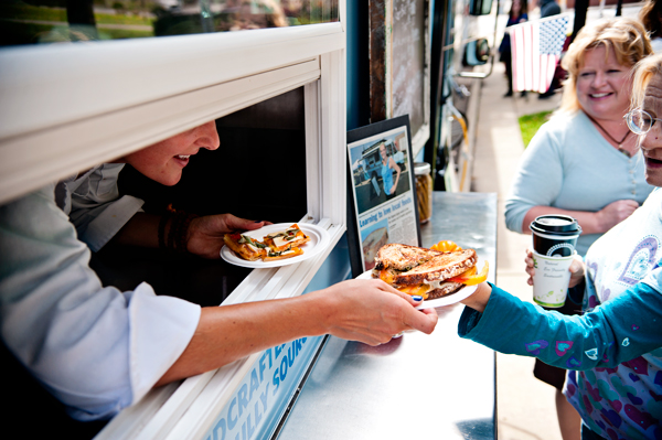 Bridgett Blough serves up some of her food to customers at Bronson Park in Kalamazoo, Michigan.