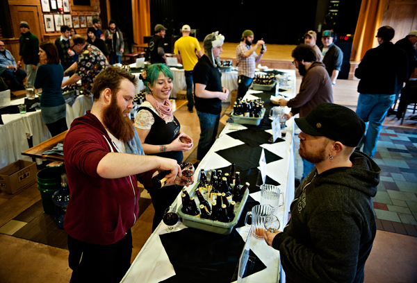 Patrick McCombs, left, and Katie Zaharion pour some vintage Bell’s Brews as Steve Hacklet, right, enjoys tasting