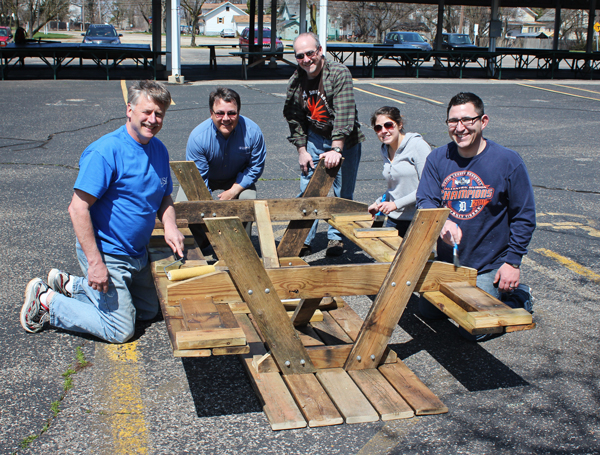 Volunteers work on picnic tables for the Kalamazoo Farmers Market on Bank Street. The materials came from an Edison neighborhood deconstruction project. The volunteers are   Dave Holzwarth of Ron Jackson Insurance; Kip Miller of Chemical Bank; Ed Wil
