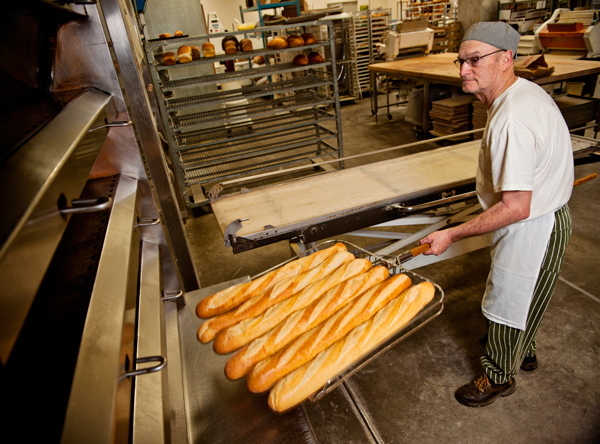 John MacKenzie takes some bread out of the ovens at MacKenzies Bakery