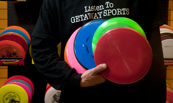 Chad Curtis holds different types of discs used in Disc Golfing