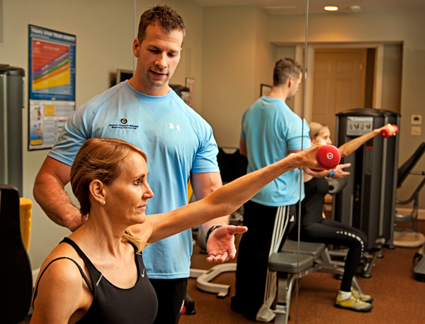 Rob Kennedy spots Anne Fischell as she works out in her home gym. 