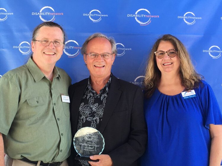 Joel Cooper, recipient of the 2022 Lifetime Achievement Award, stands with Dave Bulkoski (executive eirector of Disability Advocates of Kent County) and Mindy Kulasa (Disability Network Southwest Michigan board member).