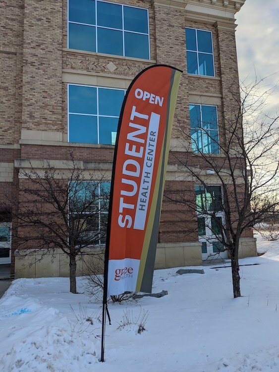 Una bandera que informa a los estudiantes de Battle Creek Central que hay una clínica escolar en el interior.