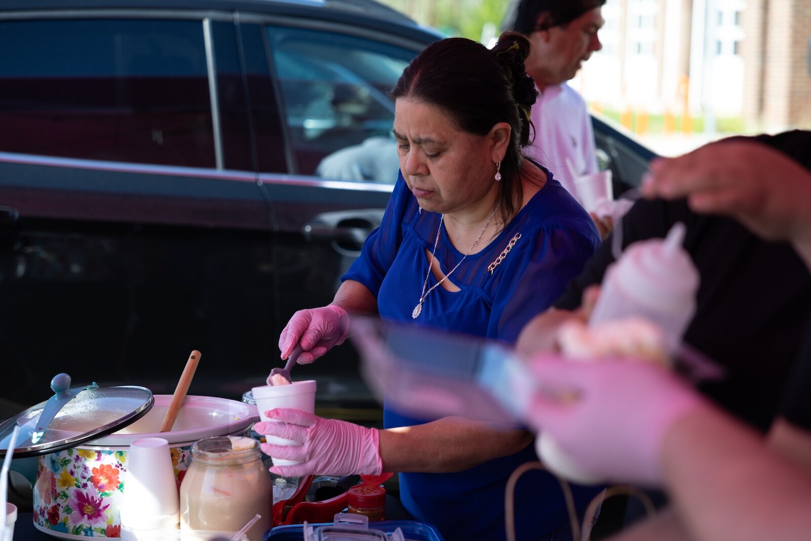 Esperanza Herrera’s mother dishes up elote to customers at the mercadito.  