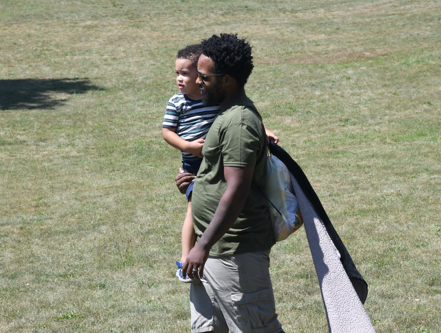 Byron Hampton carries his son Greyson during an outing at Leila Arboretum.