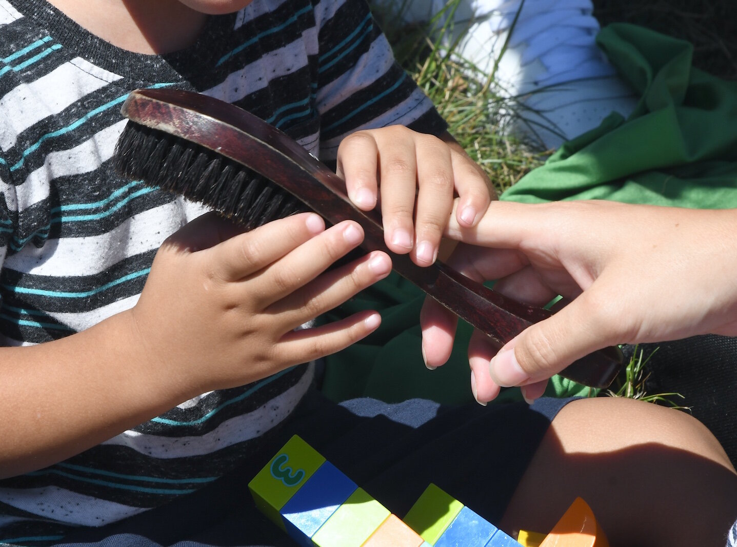 Audrina Hampton shows her son Greyson a soft-bristle brush. It is one of the contents of a sensory bag she carries for him.