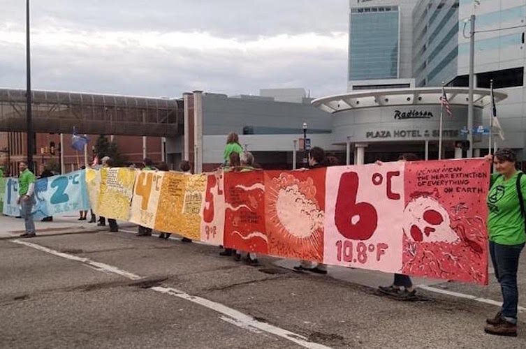 Extinction Rebellion members hold up a banner designed and painted by Bonus Saves (Patrick Herschberger)/