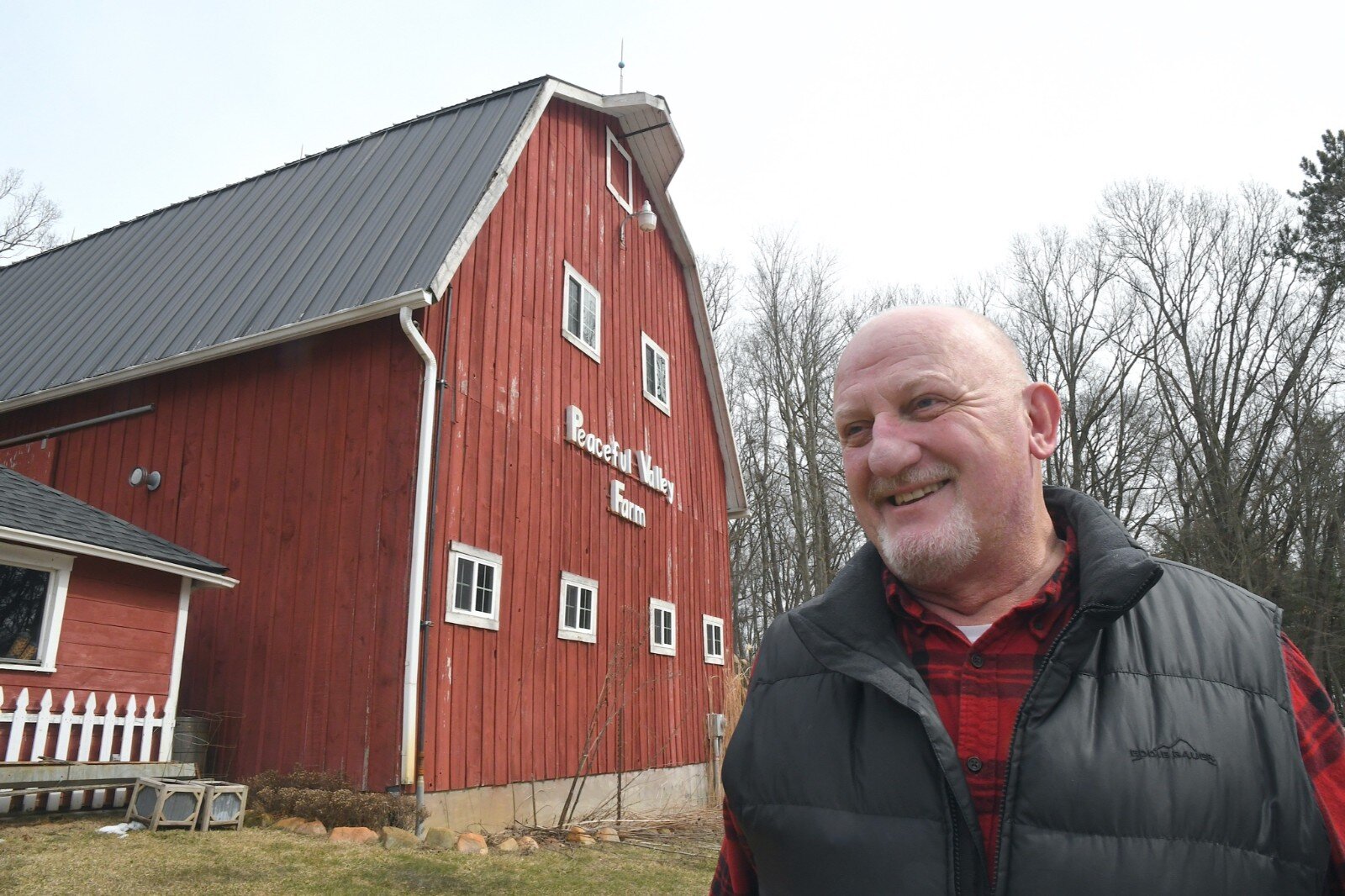 A. J. Jones stands near the barn he had moved from West Michigan Avenue in Battle Creek to his former property in Bedford Township.