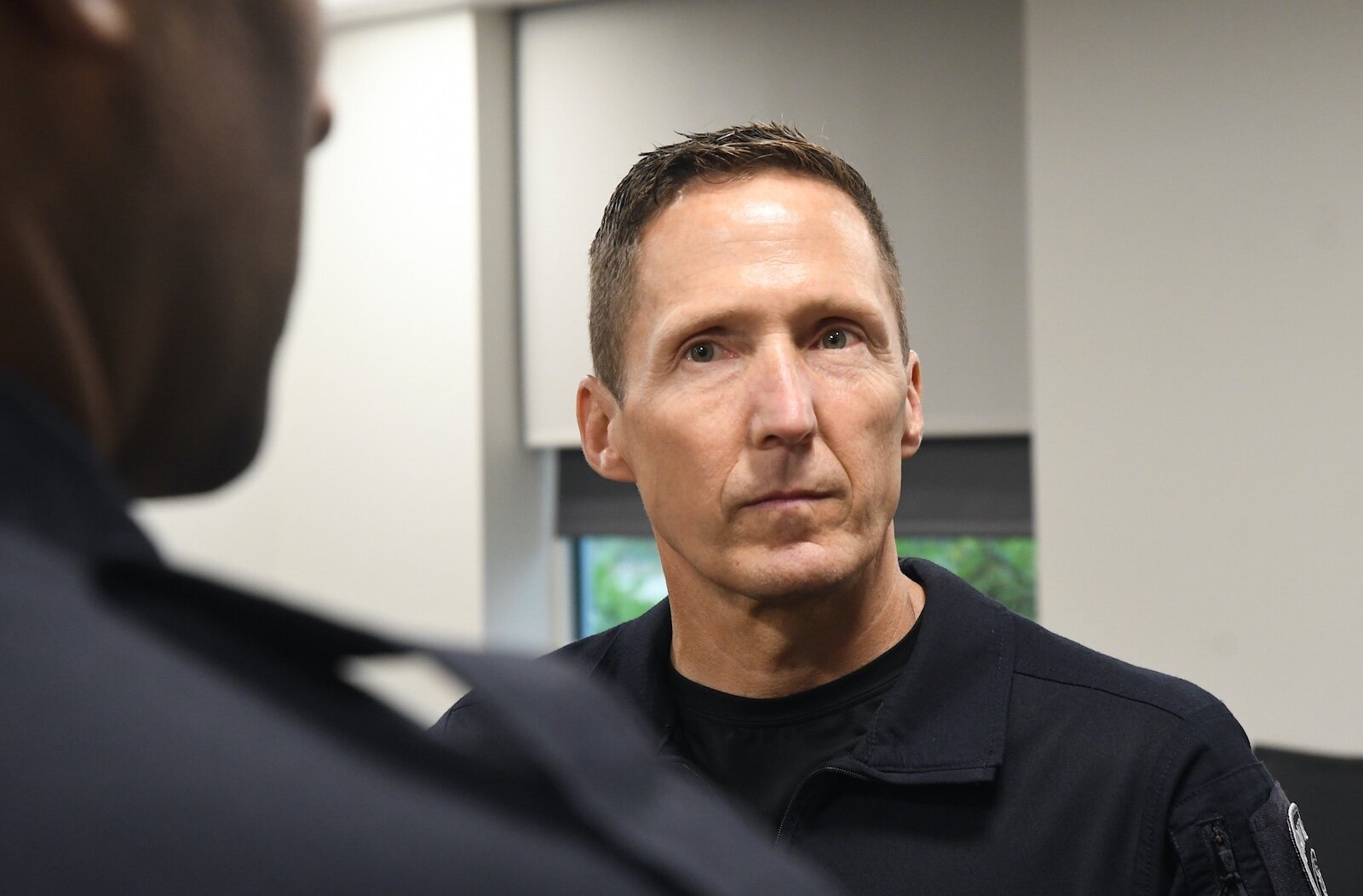 Battle Creek Police Deputy Chief Doug Bagwell, right, listens to a fellow officer.